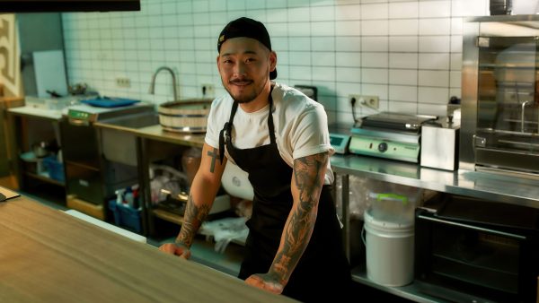 Chef-One-2560×1440 Restaurant chef standing at the kitchen counter.